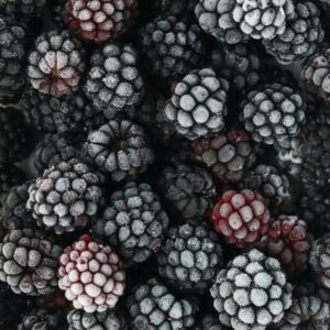 Close-up of fresh frozen blackberries covered in hoarfrost, showcasing texture and freshness.